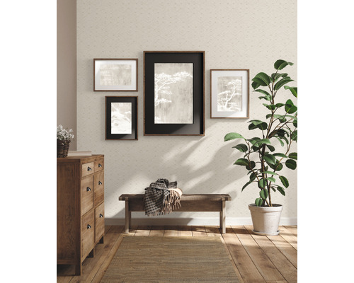 Vardagsrum med byrå, bänk, krukväxt, matta och tavlor på den strukturerade tapetväggen