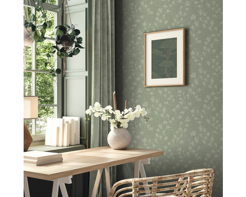 Ljust arbetsrum med skrivbord, stol, fönster, gardiner, dekoration och grön tapet med löv