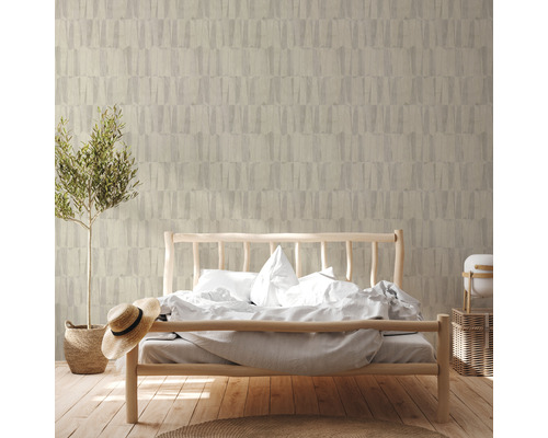 Sovrum med säng framför en vägg med mönstrad tapet och en krukväxt.