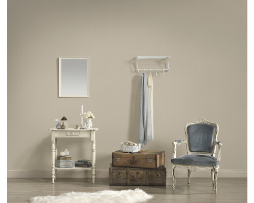 Dekorativt vardagsrum med bord, spegel, bagage, stol och hatthylla.