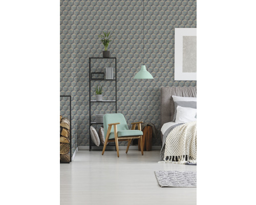 Sovrum med säng, fåtölj, hylla och tapet med geometriskt mönster