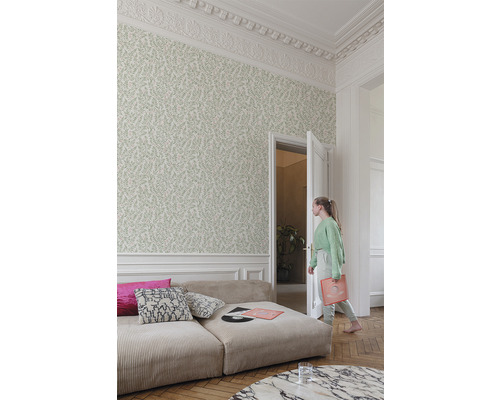 Vardagsrum med mönstrad tapet, manchester soffa och ung kvinna som håller en vinylskiva