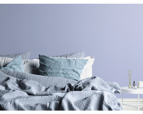 Sovrum med säng, kuddar och sidobord