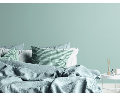 Sovrum med säng, kuddar och sängbord