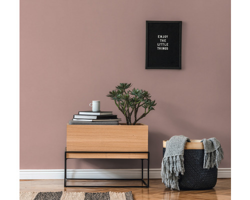 Dekorativ inredning med träskåp, växt, korg och väggtavla