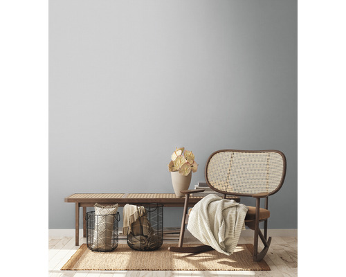 Vardagsrum med träbänk, rottinggungstol och dekorationer