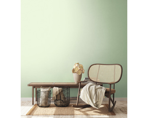 Ljus, vänlig inredning med bänk, rottingfåtölj, korgar och dekoration på en matta.