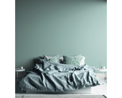 Sovrum med säng, kuddar och nattduksbord.