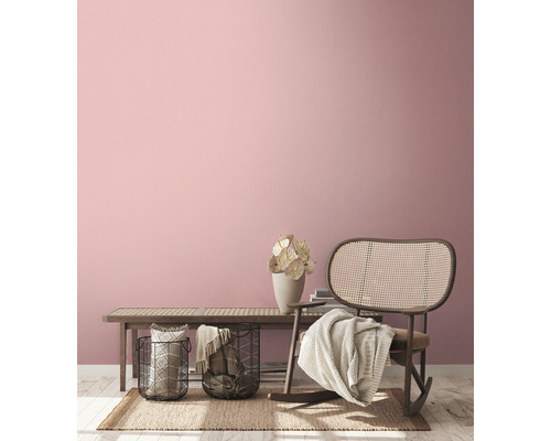 Vardagsrum med rottingfåtölj, bänk, korgar och dekorativa element för en mysig atmosfär