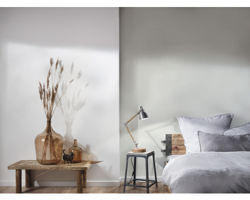 Ljus, dekorativ rumsinredning med stor glasballong, bordslampa och säng