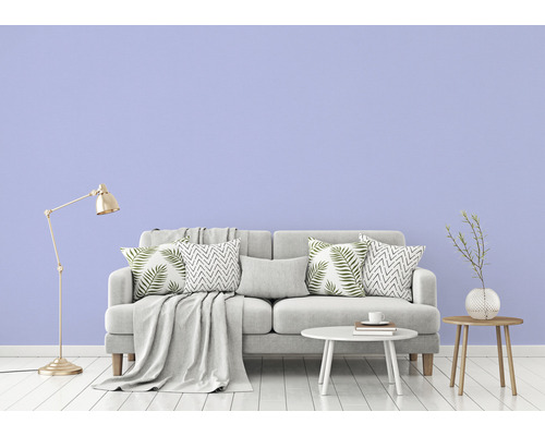 Vardagsrum med grå soffa, kuddar, filt, bord, golvlampa och dekoration