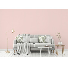 Vardagsrumsscen med soffa, kuddar, filt, lampa och sidobord.