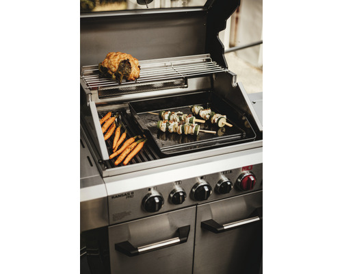 Grill i rostfritt stål med tillagade morötter, grönsaksspett och stek