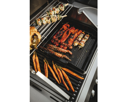 Grönsaker och spett på en grill.