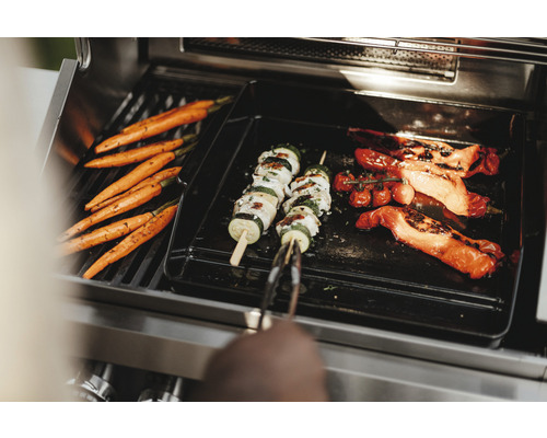 Grönsaker som morötter, zucchiniträffar och paprika på en grill.