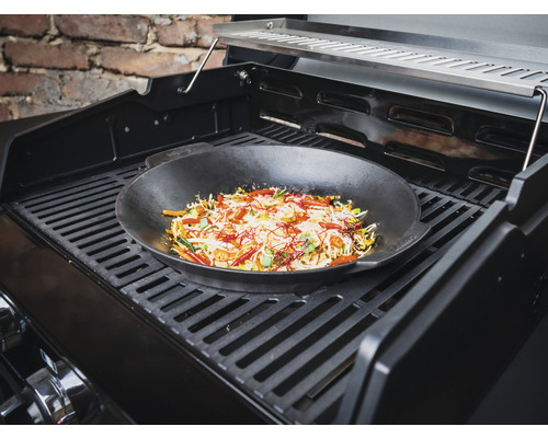 Wok med grönsaker på en grill