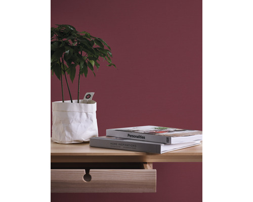 Dekorativt arrangemang med krukväxt i pappersomslag, böcker och träskrivbord