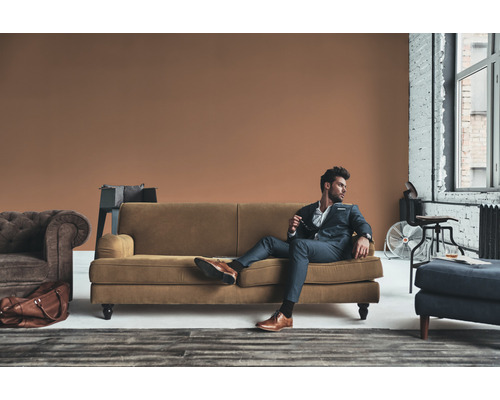 En man i kostym kopplar av på en soffa i ett vardagsrum.