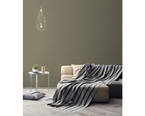 Vardagsrum med soffa, filt, lampa och sidobord