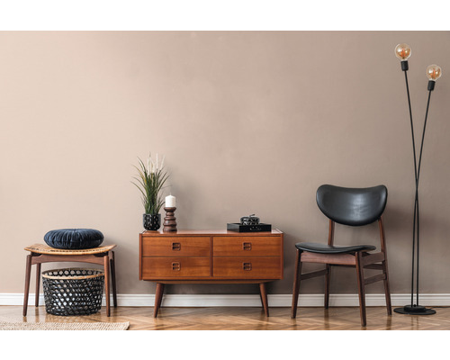 Vardagsrum med byrå, stol och golvlampa