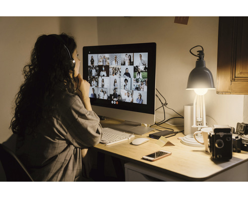 Kvinna deltar i en videokonferens vid ett datorbord