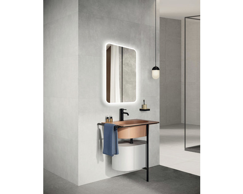 Modernt badrum med tvättställ, upplyst spegel och handduk