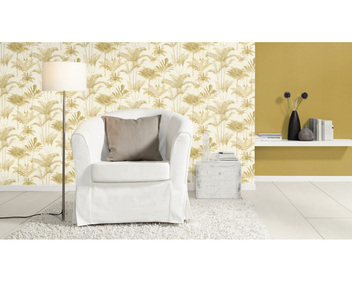 Vardagsrum med fåtölj, golvlampa och tapet med växtmönster