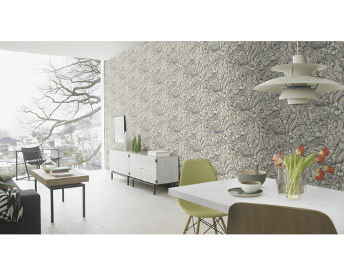 Vardagsrum med blommig tapet, matbord, stolar och skänk