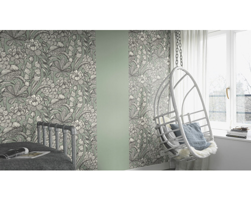Rum med blommig tapet, säng och hängande stol