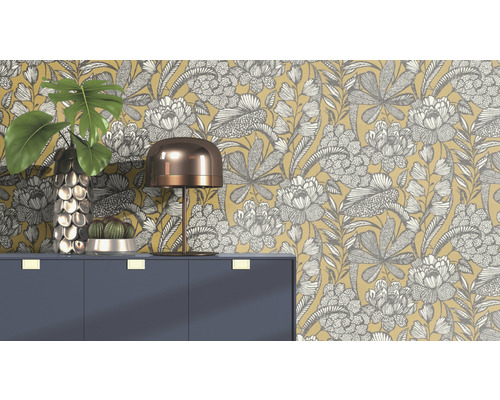 Dekorativ scen med blommig tapet, byrå, lampa, vas och kaktus