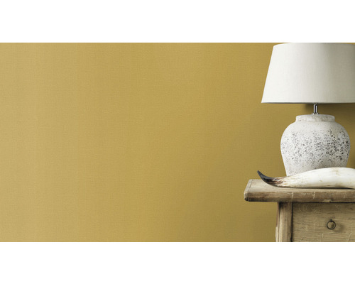 Närbild av en vägg med färg, sänglampa och dekoration