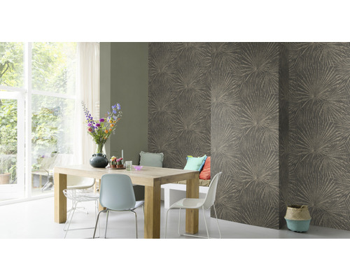 Matsal med träbord, stolar och en vägg med blommönstrad tapet