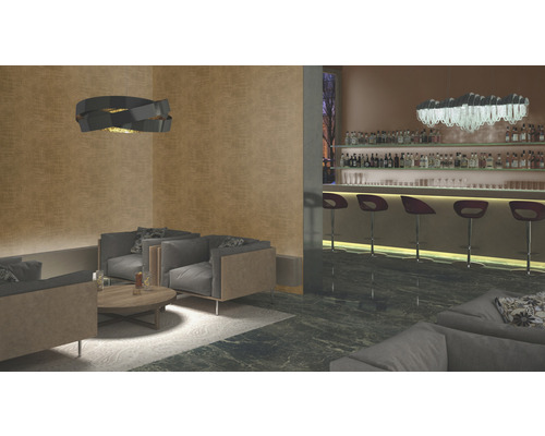 Loungeområde med fåtöljer, soffbord, taklampa och bar i bakgrunden