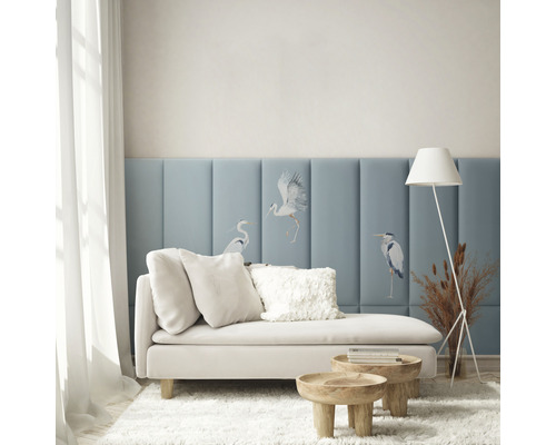 Vardagsrum med soffa, kuddar, sidobord, golvlampa och väggpaneler med fågelmotiv för en ljus och organiserad atmosfär.