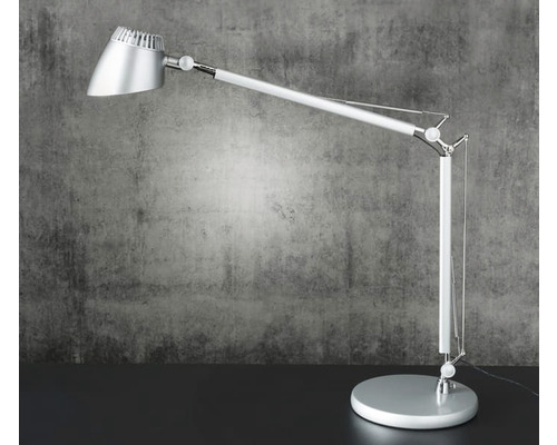 Silverfärgad skrivbordslampa med justerbar arm och rund fot.