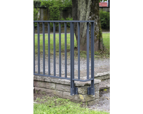 Metallstaket på en stenmur i trädgården