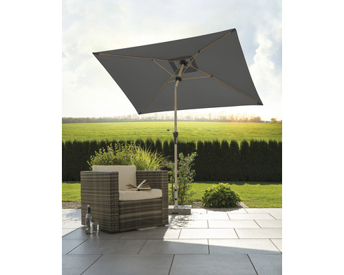 Fyrkantigt trädgårdsparasoll bredvid korgfåtölj på terrassen