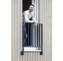 Man står på en fönsterbalkong med metallräcke.