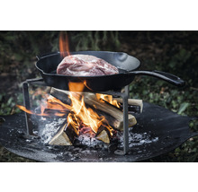 Kött i stekpanna över öppen eld på eldstad