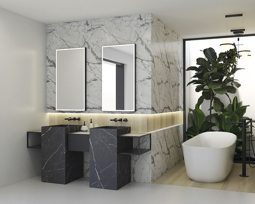 Ljust badrum med två handfat, speglar, badkar och växter