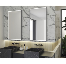 Badrum med två upplysta speglar, två handfat i marmor och armaturer