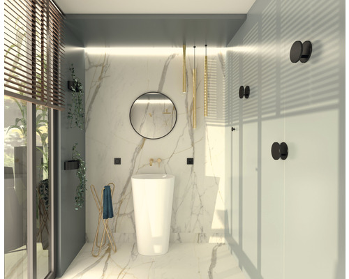 Ljust badrum med fristående handfat, rund spegel och gyllene accenter