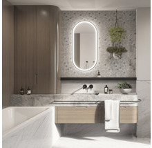 Ljust badrum med tvättställ, spegel med belysning och badrumsskåp