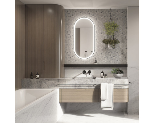 Ljust badrum med tvättställ, spegel med belysning och badrumsskåp