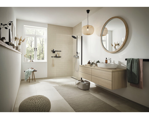 Ljust badrum med tvättställ, spegel, dusch och tillbehör