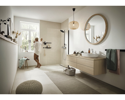 Ljust badrum med dusch, tvättställ, spegel och belysning