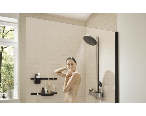 Dusch med duschvägg, takdusch och vägghyllor i ett ljust badrum.