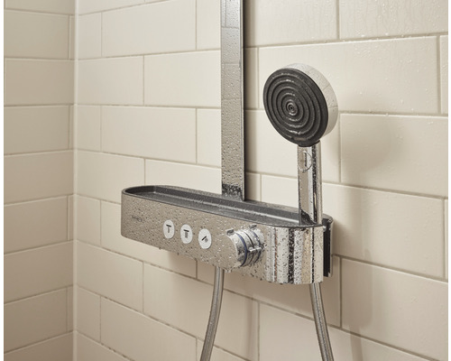 Duschsystem med handdusch och hylla mot en kakelvägg