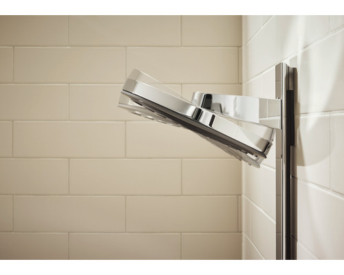 Kromfärgat duschhuvud monterat på kakelvägg