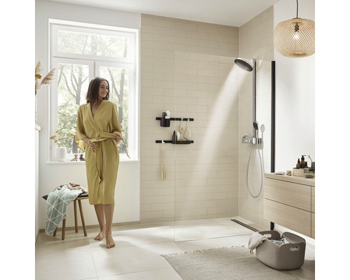 Ljust badrum med dusch, förvaringshylla och kvinna i morgonrock